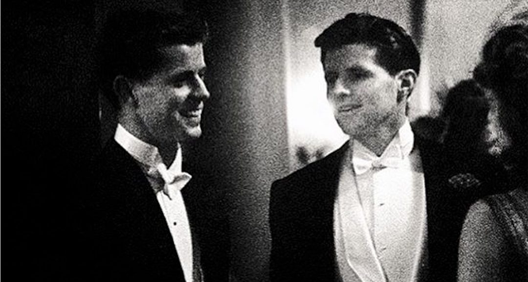 Fotografia em preto e branco de dois jovens de fraque numa recepção noturna, Joe Kennedy Jr. e seu irmão John